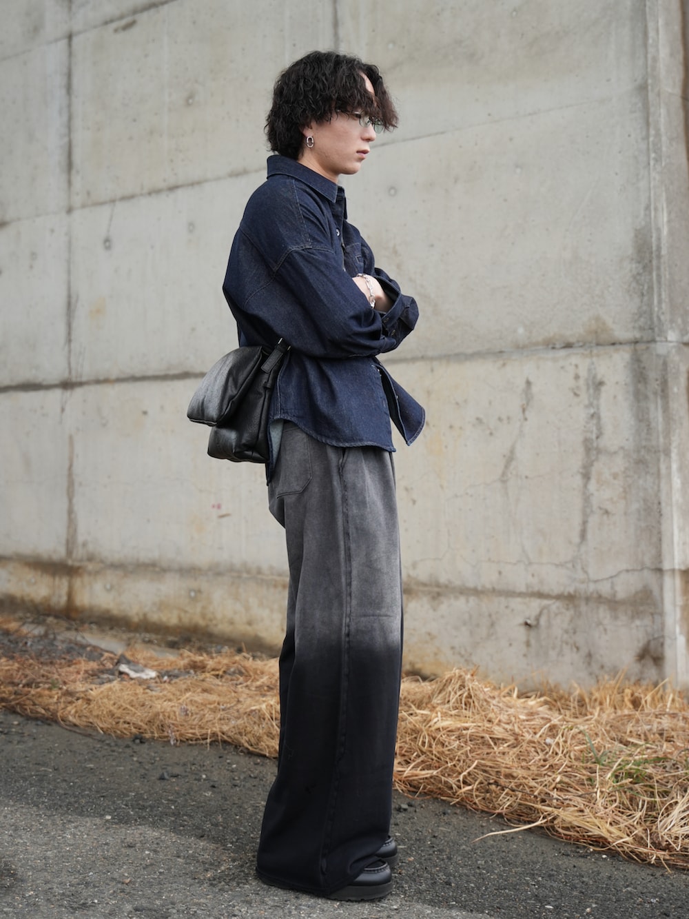 ブラック系のスウェットパンツ、ブラック系のショルダーバッグ、ブラック系のモカシン/デッキシューズを着用したメンズの冬コーディネートの3枚目の写真