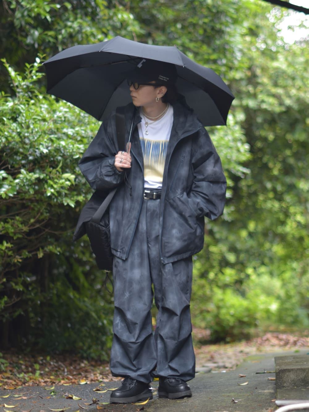 「やっぱり帽子が好き、雨の日コーデ、Tシャツ、レイヤードスタイル、ワイドパンツ、ショルダーバッグ、セットアップ、スニーカー、キャップ、お出かけコーデ、低身長コーデ、モノトーン、デートコーデ、サングラス、きれいめカジュアル」｜「soerteのTotal pattern loose mountain parker （Water-repellent ）/トータルパターンルーズマウンテンパーカー（撥水加工）（マウンテンパーカー、ブラック系）」を使った、熊谷一平さん（骨格ナチュラル・メンズ・165cm）の春コーディネートの2枚目の写真