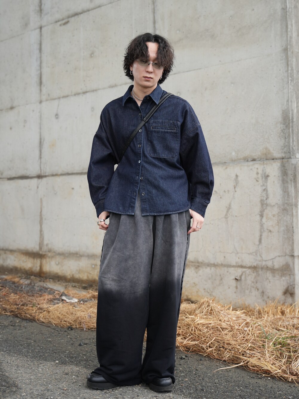 ブラック系のスウェットパンツ、ブラック系のショルダーバッグ、ブラック系のモカシン/デッキシューズを着用したメンズの冬コーディネートの2枚目の写真