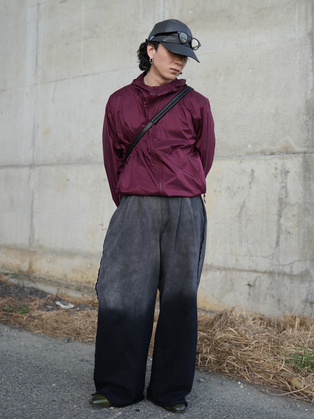 ブラック系のスウェットパンツ、ブラック系のショルダーバッグ、グリーン系のローファーを着用したメンズの春コーディネートの2枚目の写真