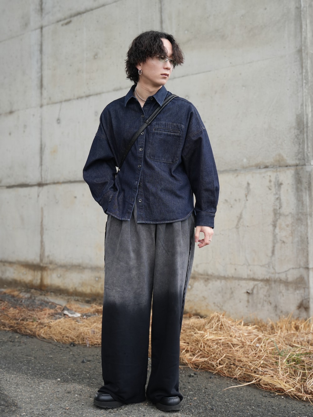 ブラック系のスウェットパンツ、ブラック系のショルダーバッグ、ブラック系のモカシン/デッキシューズを着用したメンズの冬コーディネートの5枚目の写真