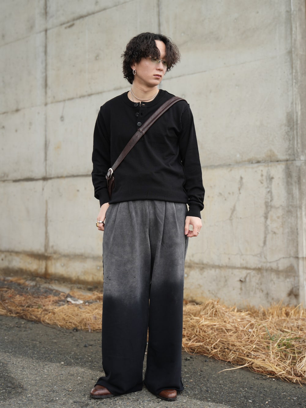 ブラック系のニット/セーター、ブラック系のスウェットパンツ、ブラウン系のショルダーバッグを着用したメンズの春コーディネートの3枚目の写真