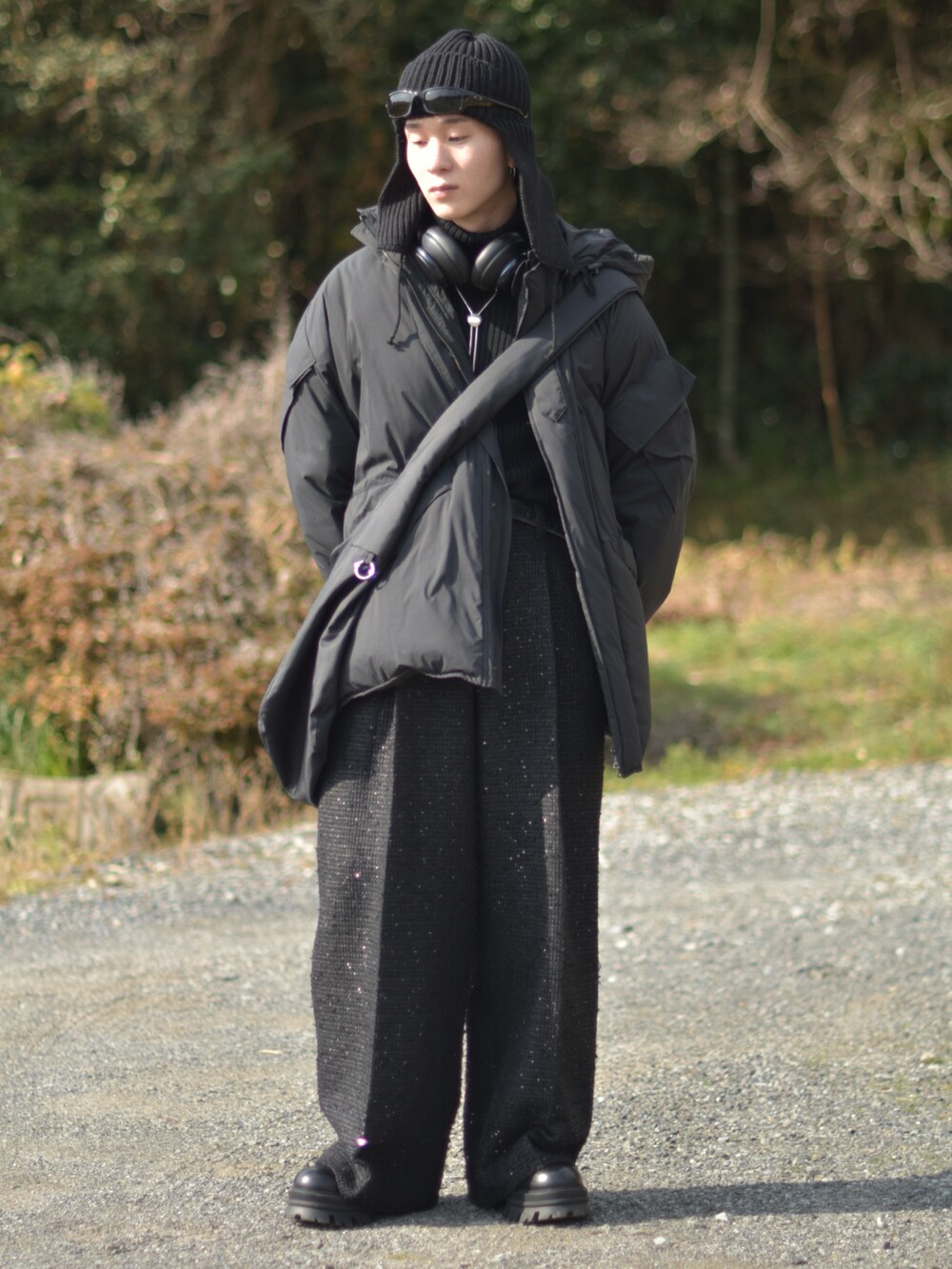 ブラック系のダウンジャケット/コート、ブラック系のスラックス、ブラック系のブーツを着用したメンズの冬コーディネートの5枚目の写真