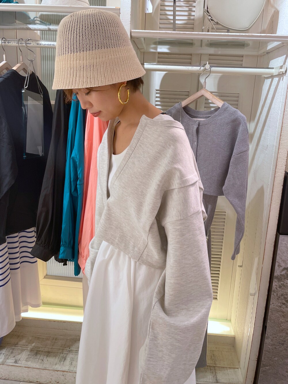 ブラック系のワンピース、ホワイト系のサンダル、ホワイト系のハットを着用したレディースの春コーディネートの4枚目の写真