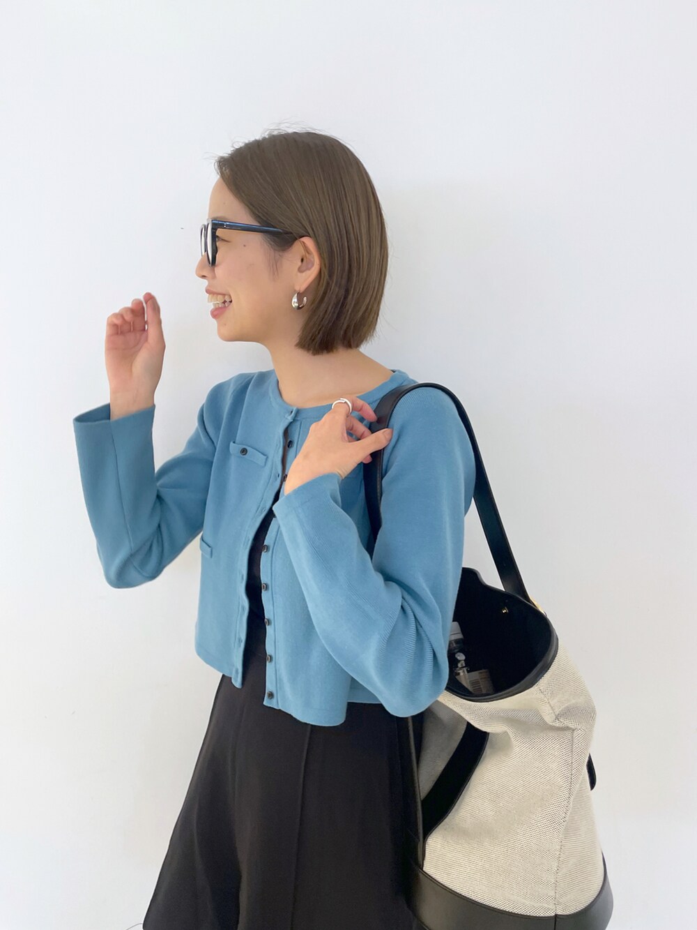 ブラウン系のショルダーバッグ、ブラック系のその他パンツ、ブルー系のカーディガン/ボレロを着用したレディースの春コーディネートの3枚目の写真