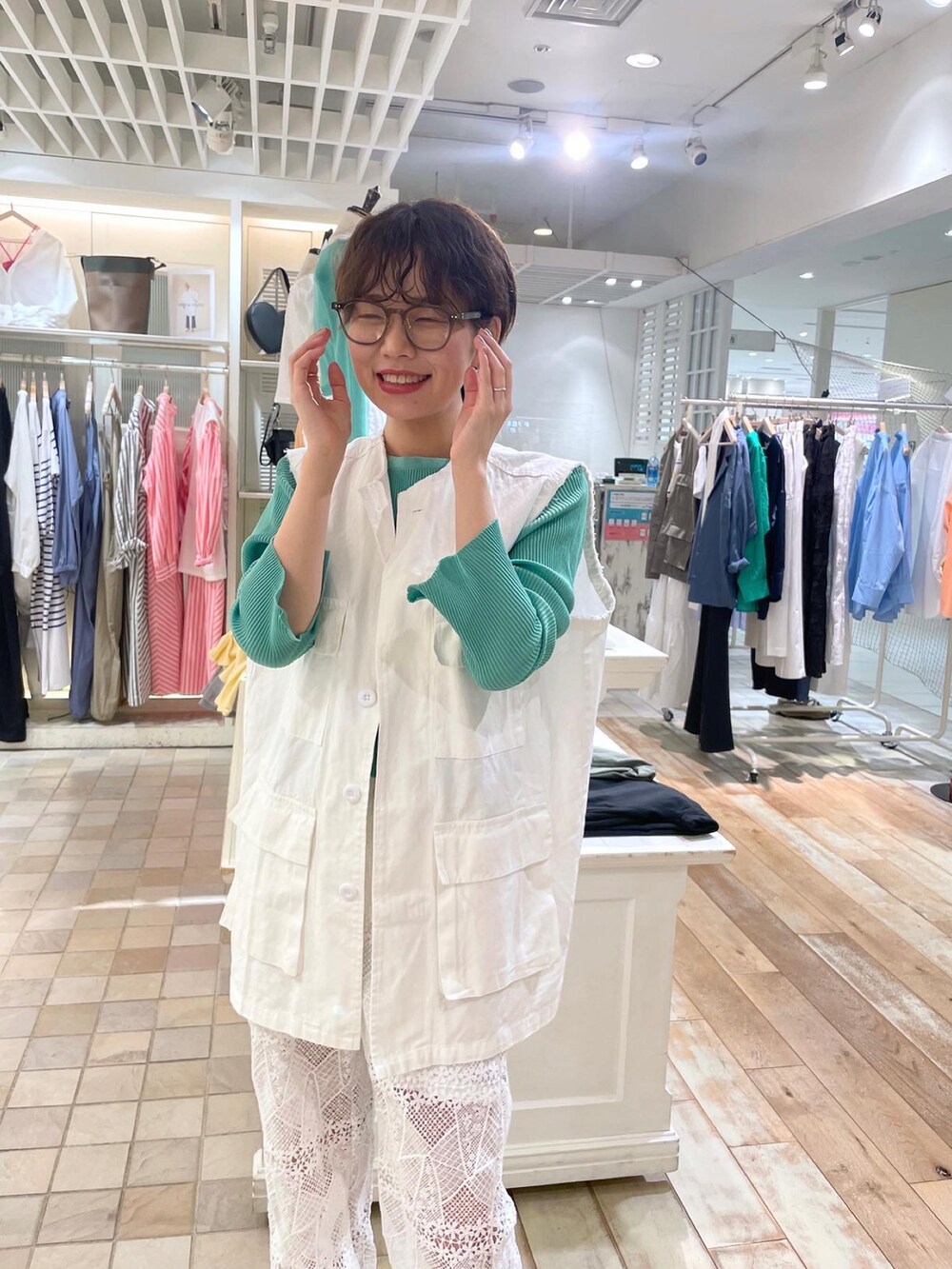 ホワイト系のベスト、グリーン系のカーディガン/ボレロ、ホワイト系のその他パンツを着用したレディースの春コーディネートの2枚目の写真