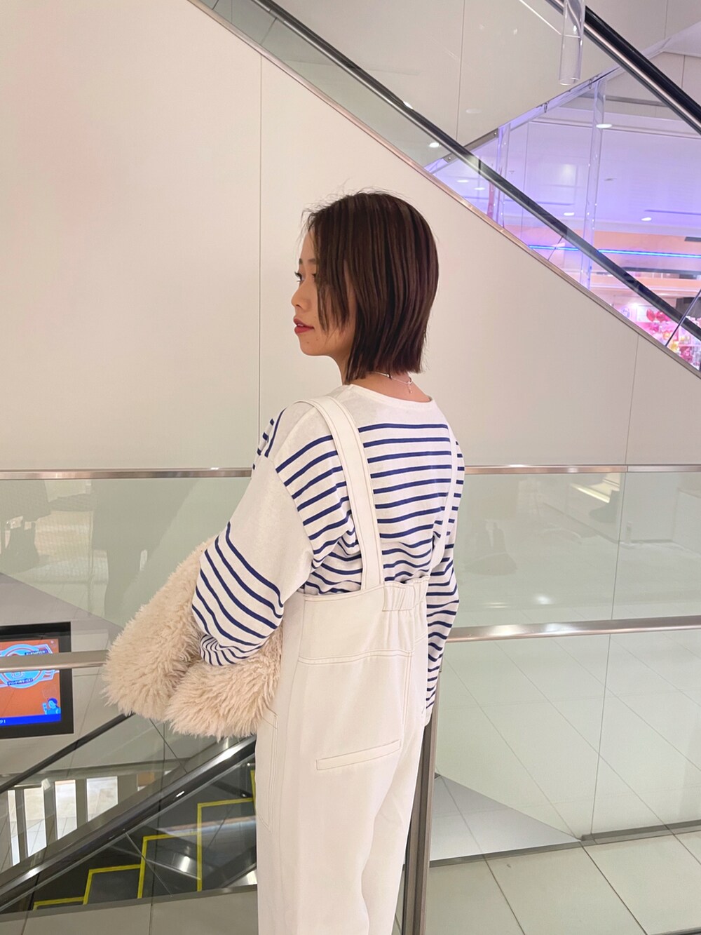 ブルー系のTシャツ/カットソー、ホワイト系のベスト、ホワイト系のサロペット/オーバーオールを着用したレディースの冬コーディネートの4枚目の写真