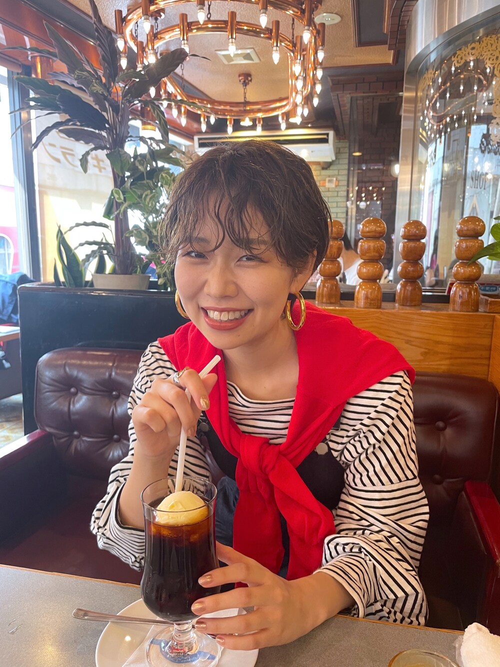 ブラウン系のサンダル、ホワイト系のTシャツ/カットソー、レッド系のニット/セーターを着用したレディースの春コーディネートの3枚目の写真