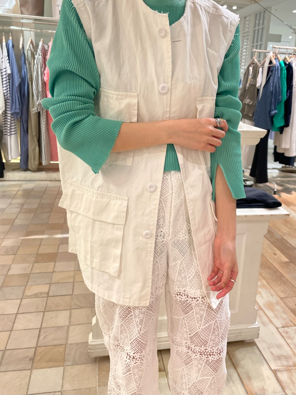 ホワイト系のベスト、グリーン系のカーディガン/ボレロ、ホワイト系のその他パンツを着用したレディースの春コーディネートの3枚目の写真