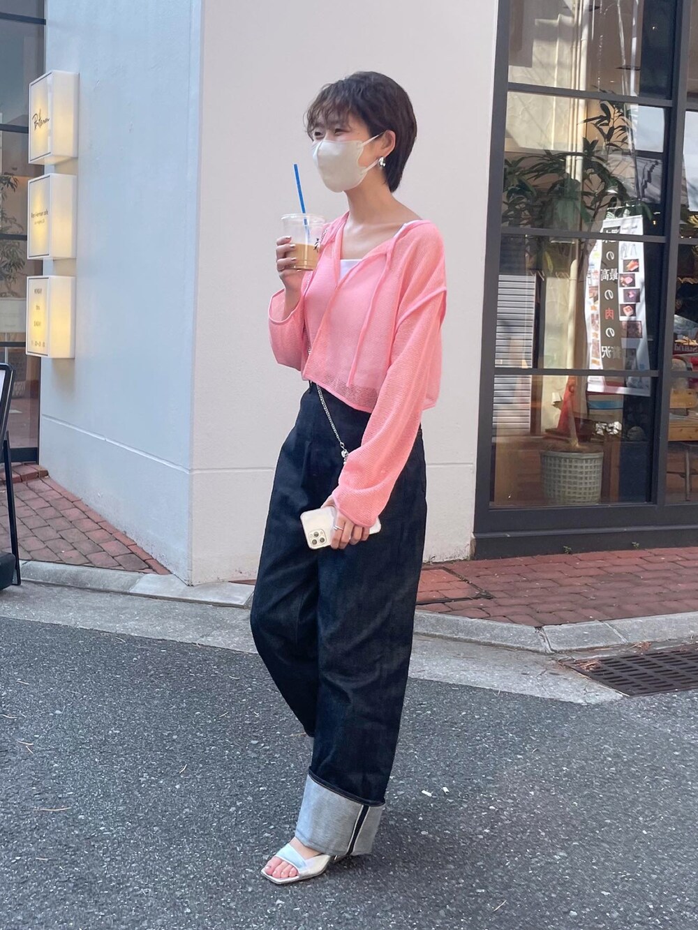 ピンク系のカーディガン/ボレロ、ブルー系のデニムパンツを着用したレディースの春コーディネートの2枚目の写真