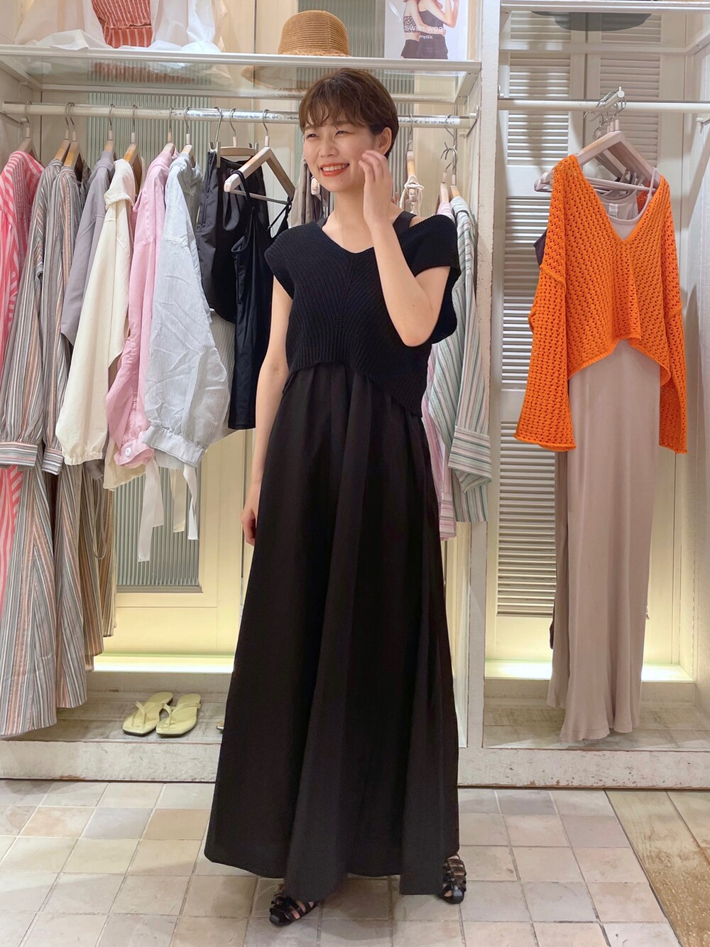 ブラック系のトートバッグ、ホワイト系のワンピースを着用したレディースの夏コーディネートの3枚目の写真