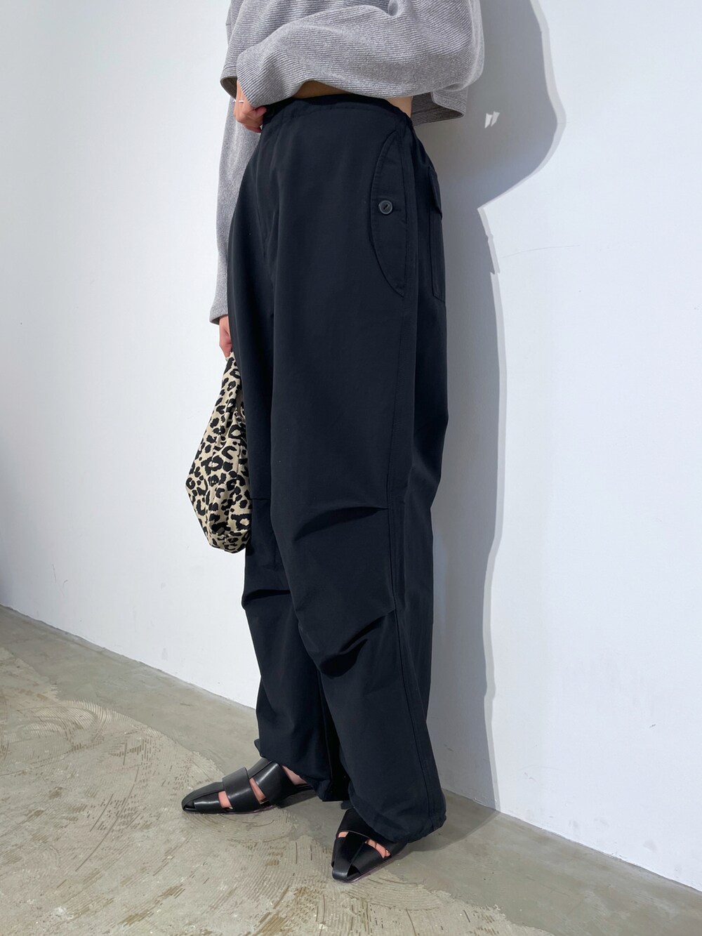 ブラック系のパンツ、ブラック系のワンピース、ブラック系のサンダルを着用したレディースの春コーディネートの3枚目の写真