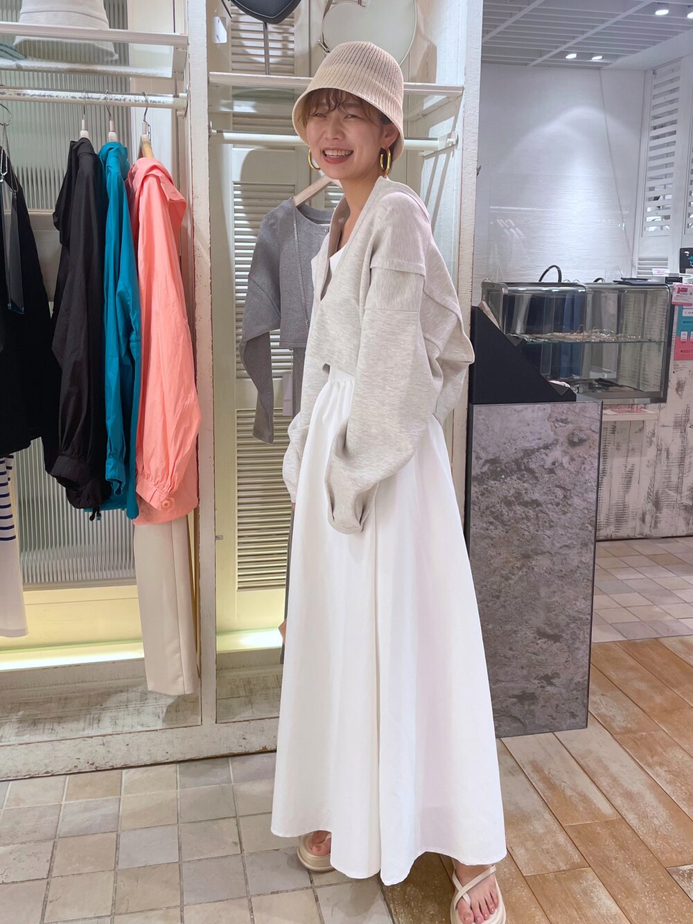 ブラック系のワンピース、ホワイト系のサンダル、ホワイト系のハットを着用したレディースの春コーディネートの2枚目の写真