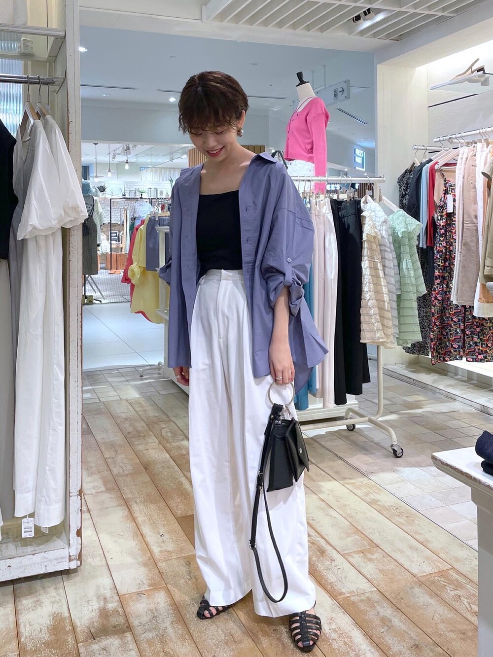 ブルー系のシャツ/ブラウス、ホワイト系のスラックス、ブラック系のサンダルを着用したレディースの夏コーディネートの2枚目の写真