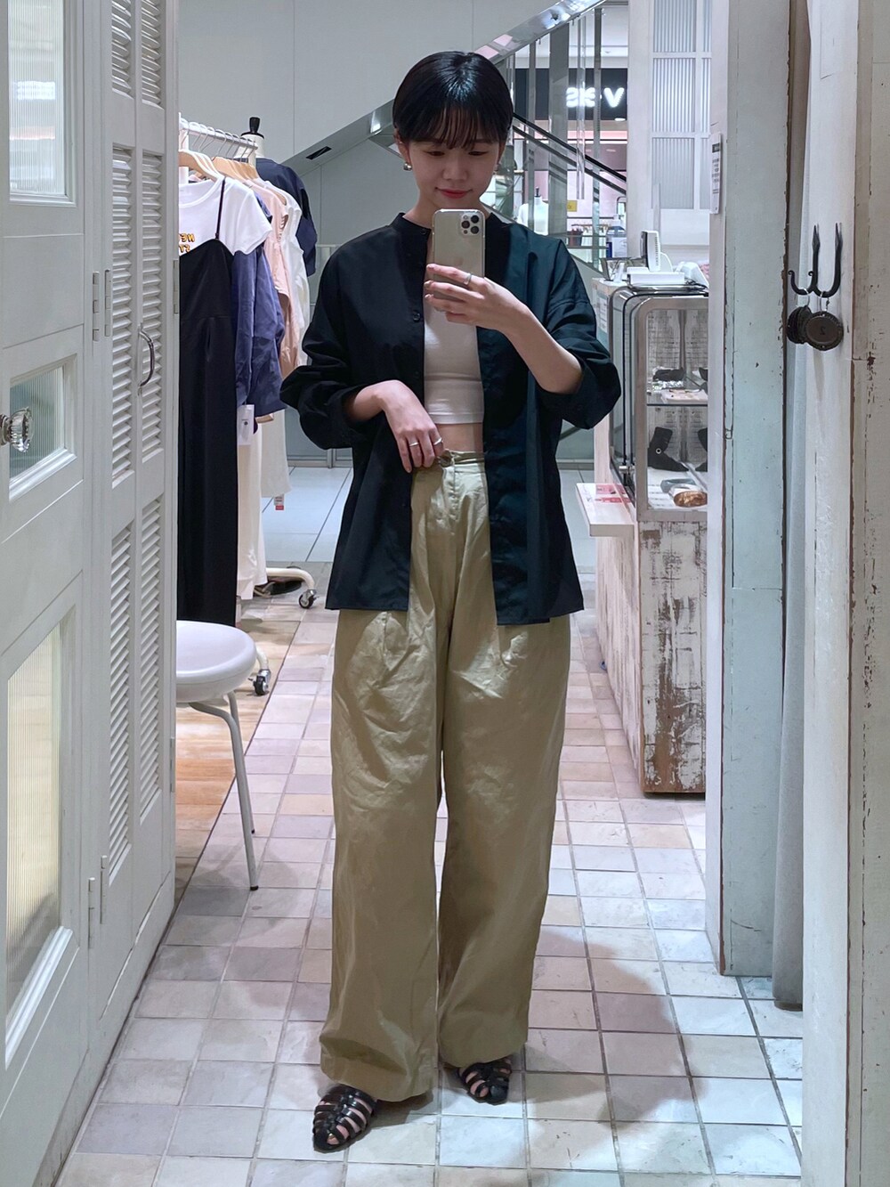 ベージュ系のチノパンツ、ブラック系のシャツ/ブラウスを着用したレディースの夏コーディネートの2枚目の写真