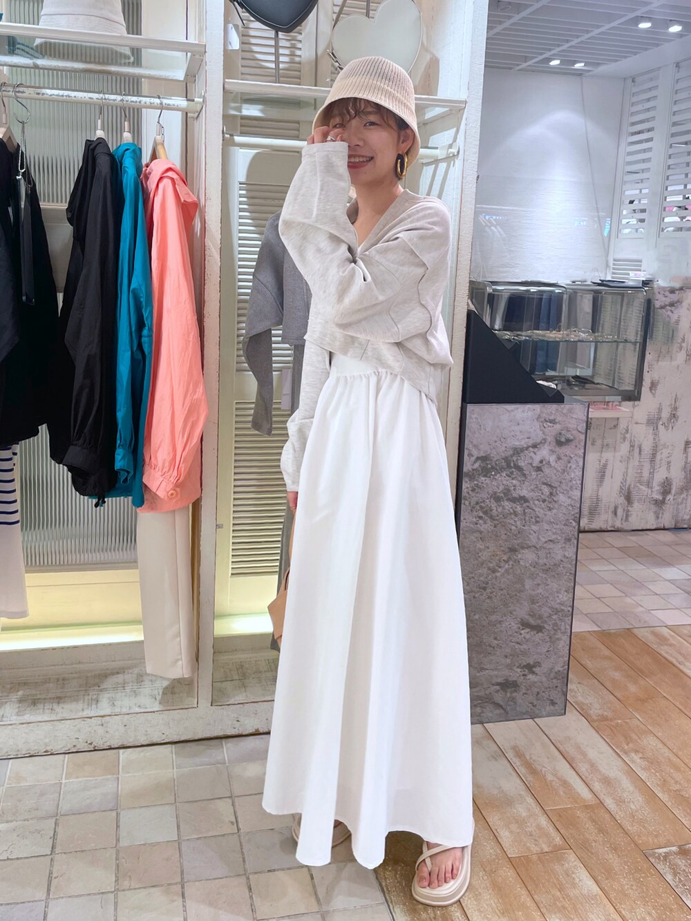ブラック系のワンピース、ホワイト系のサンダル、ホワイト系のハットを着用したレディースの春コーディネートの3枚目の写真