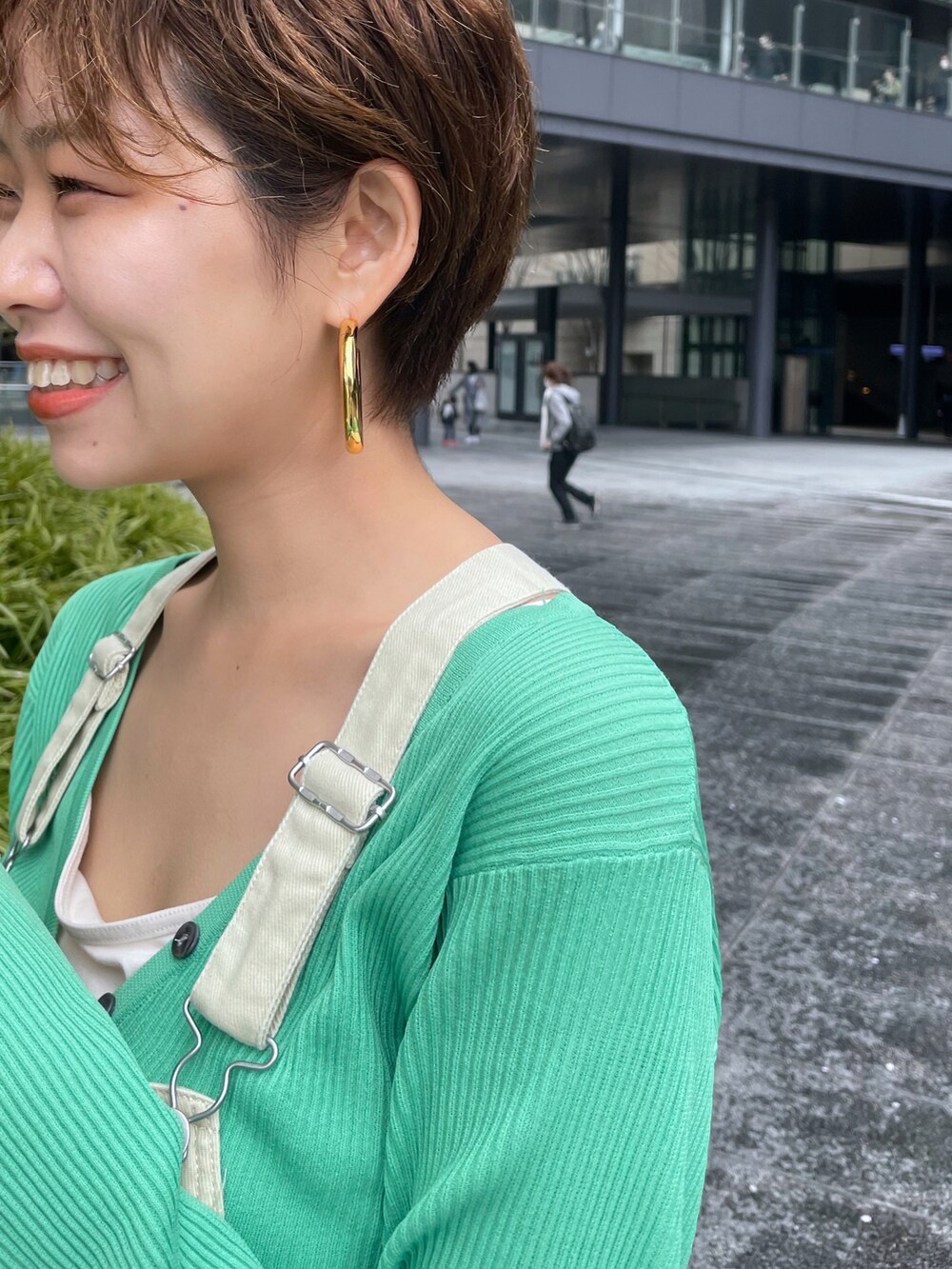 ベージュ系のサンダル、ベージュ系のサロペット/オーバーオール、グリーン系のカーディガン/ボレロを着用したレディースの春コーディネートの3枚目の写真