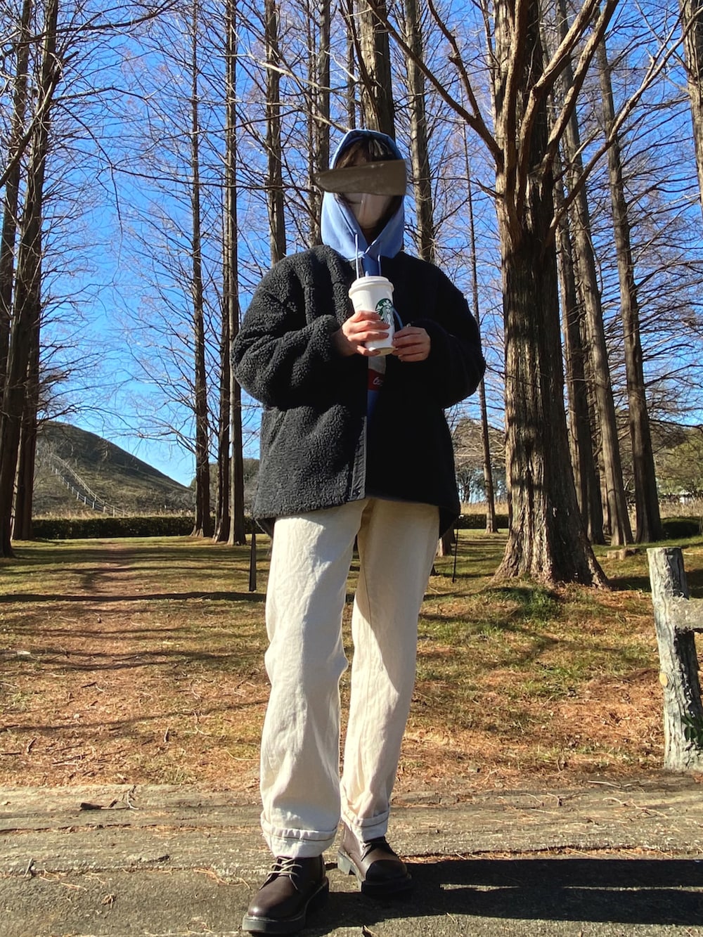 グレー系のノーカラージャケット、ブルー系のパーカー、ホワイト系のデニムパンツを着用したレディースの冬コーディネートの2枚目の写真