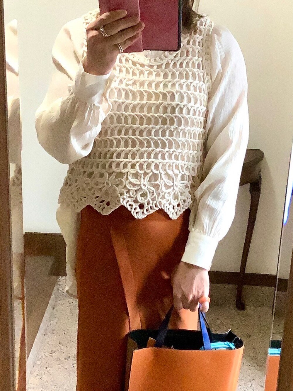 オレンジ系のトートバッグ、ブラウン系のスカートを着用したレディースの春コーディネートの2枚目の写真