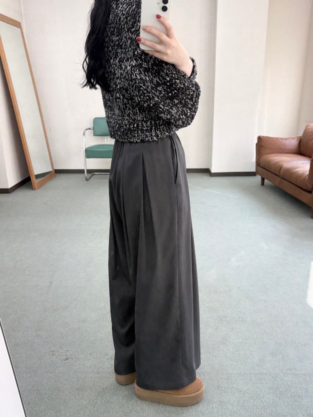 グレー系のその他パンツ、ブラック系のニット/セーター、イエロー系のブーツを着用したレディースの冬コーディネートの3枚目の写真