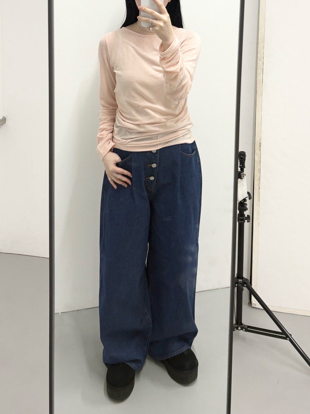 ピンク系のTシャツ/カットソー、ブルー系のデニムパンツ、ブラック系のブーツを着用したレディースの冬コーディネートの2枚目の写真