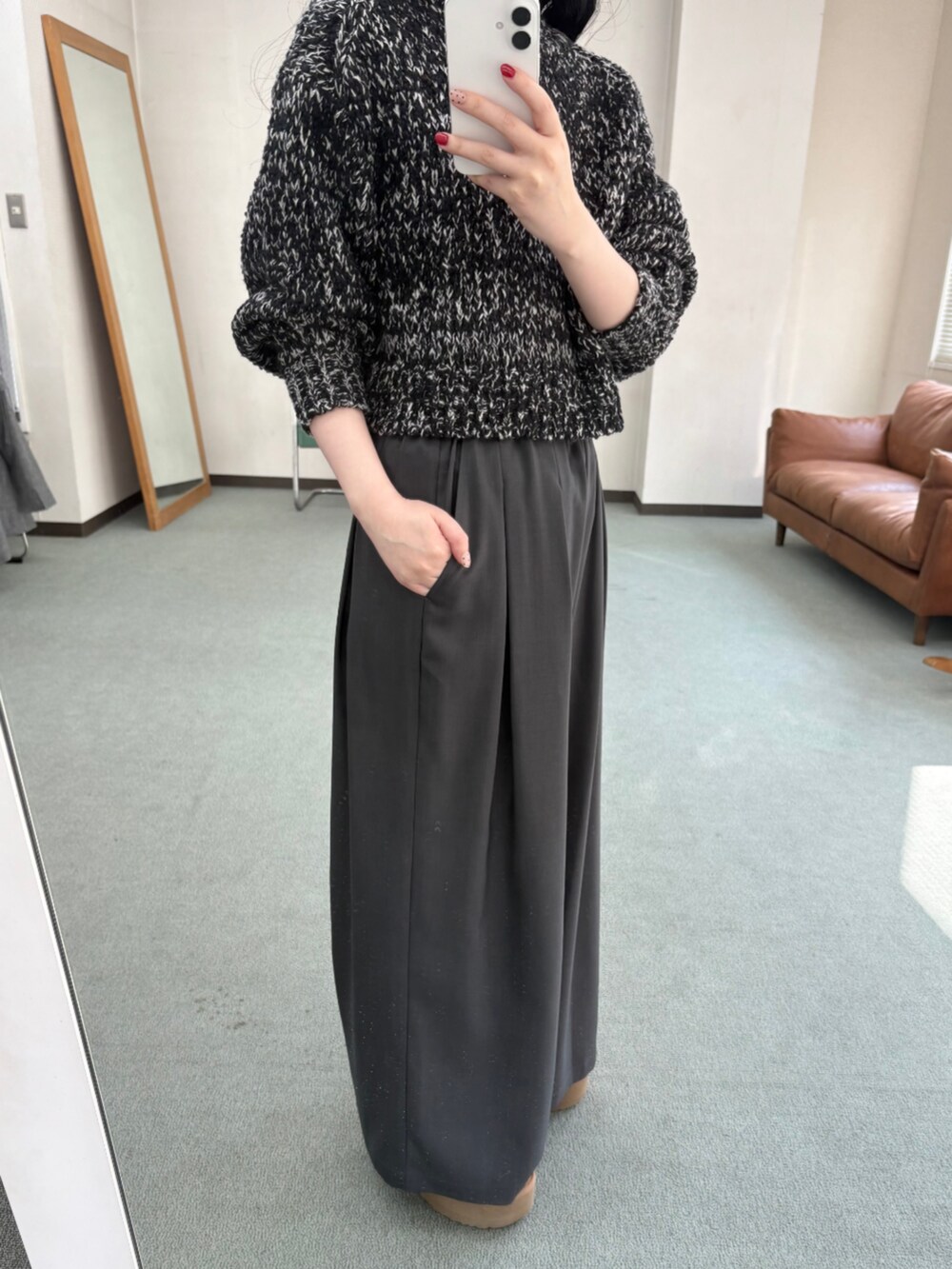 グレー系のその他パンツ、ブラック系のニット/セーター、イエロー系のブーツを着用したレディースの冬コーディネートの2枚目の写真