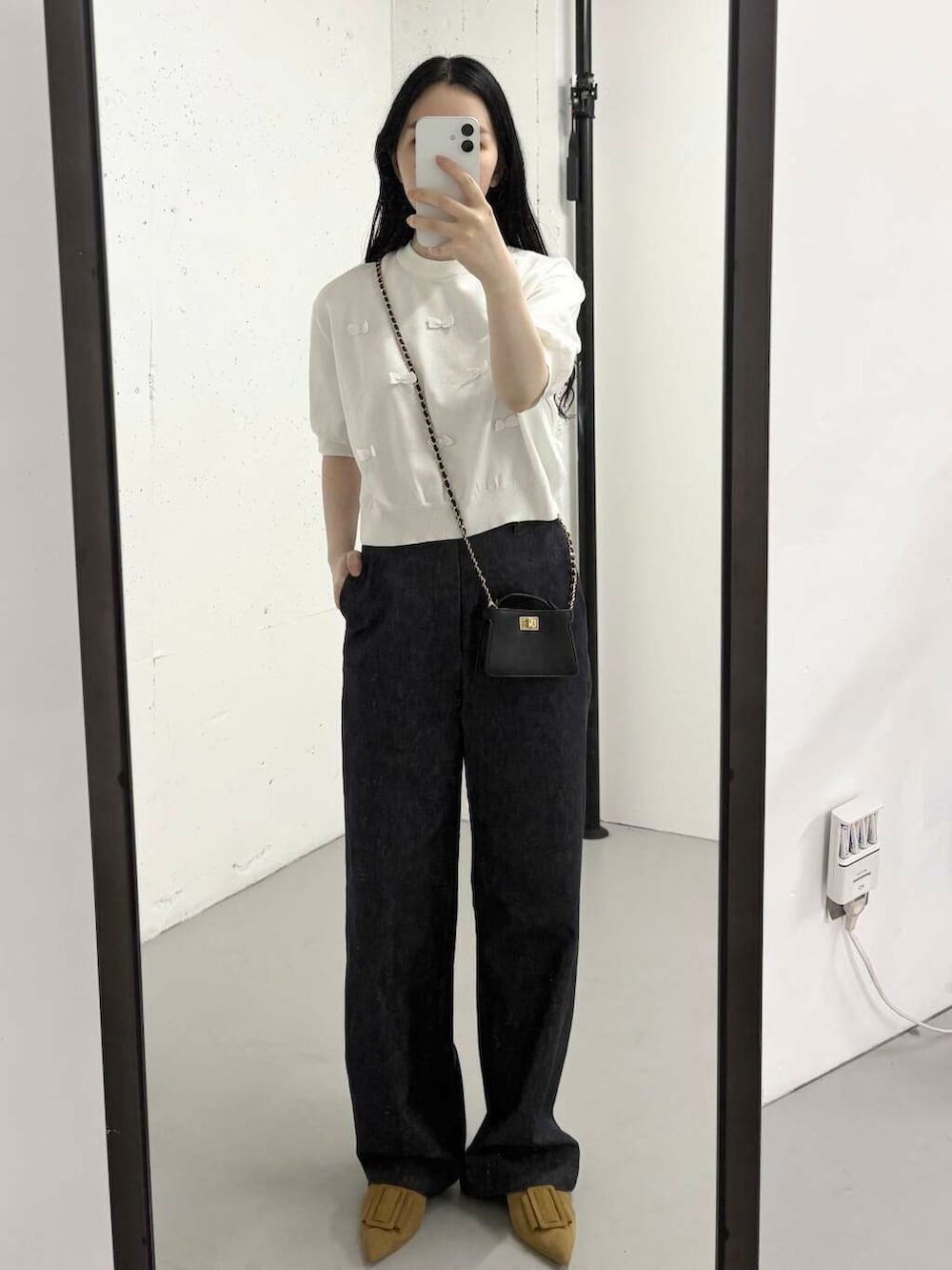 ブルー系のデニムパンツ、ホワイト系のニット/セーター、イエロー系のサンダルを着用したレディースの夏コーディネートの3枚目の写真