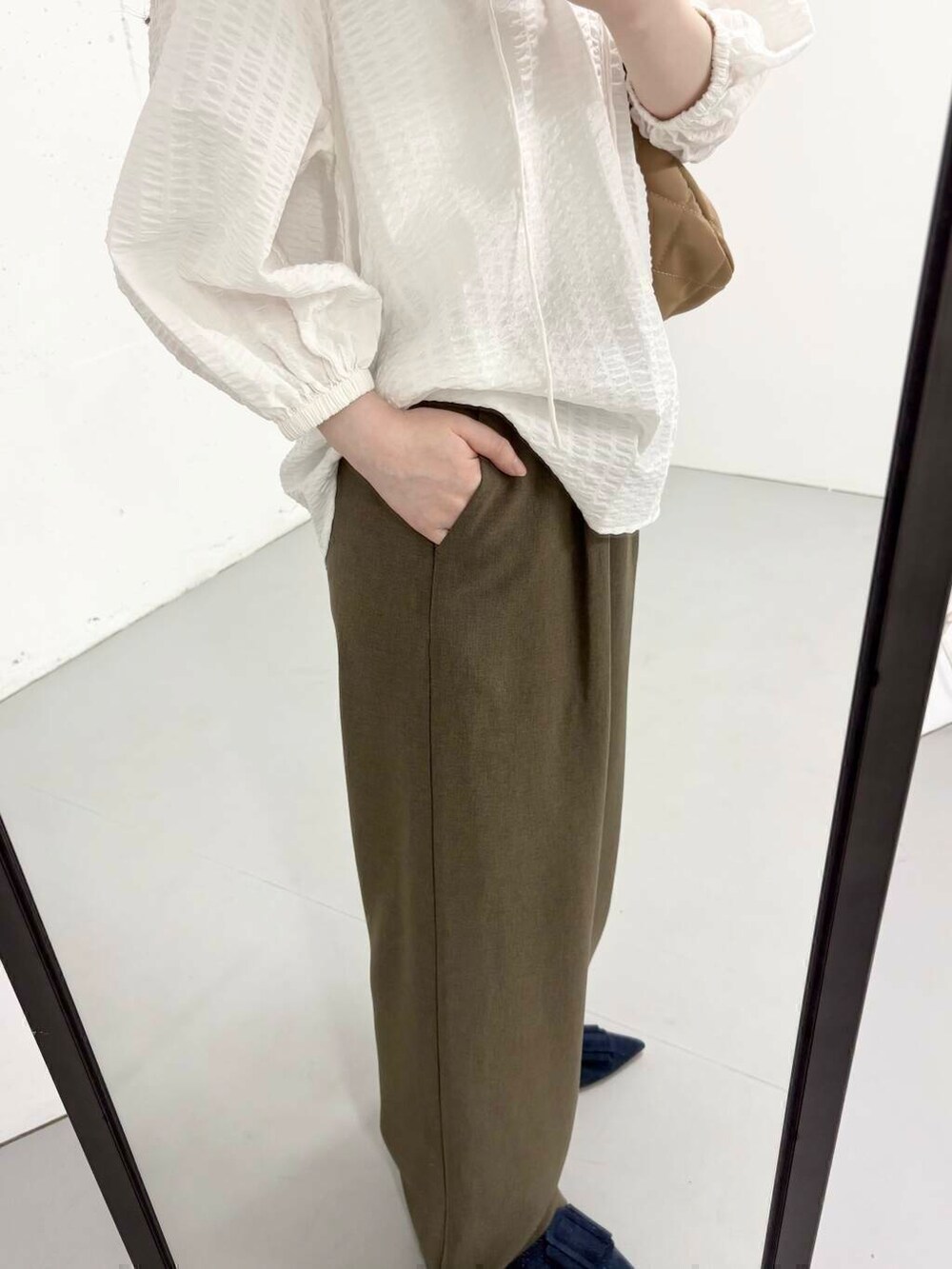 ブラウン系のその他パンツ、ベージュ系のハンドバッグ、ホワイト系のシャツ/ブラウスを着用したレディースの夏コーディネートの4枚目の写真