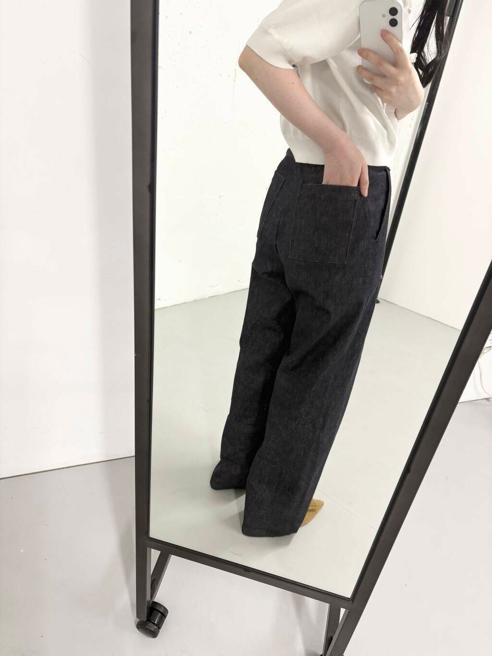 ブルー系のデニムパンツ、ホワイト系のニット/セーター、イエロー系のサンダルを着用したレディースの夏コーディネートの4枚目の写真