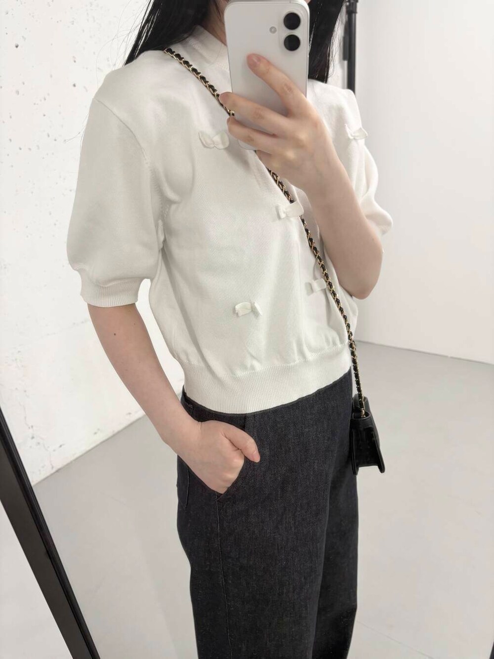 ブルー系のデニムパンツ、ホワイト系のニット/セーター、イエロー系のサンダルを着用したレディースの夏コーディネートの2枚目の写真