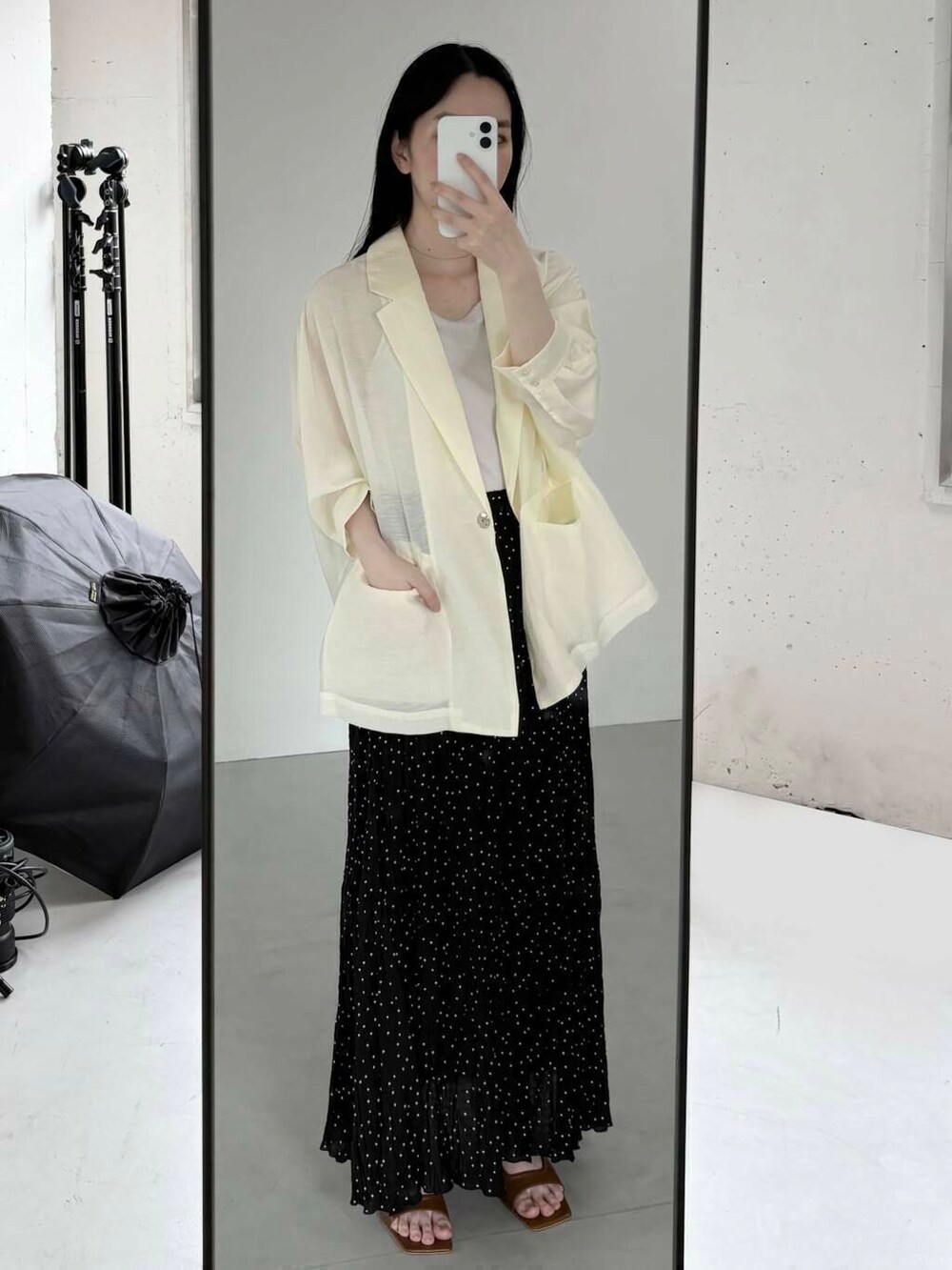ホワイト系のその他アウター、ブラック系のスカートを着用したレディースの夏コーディネートの2枚目の写真