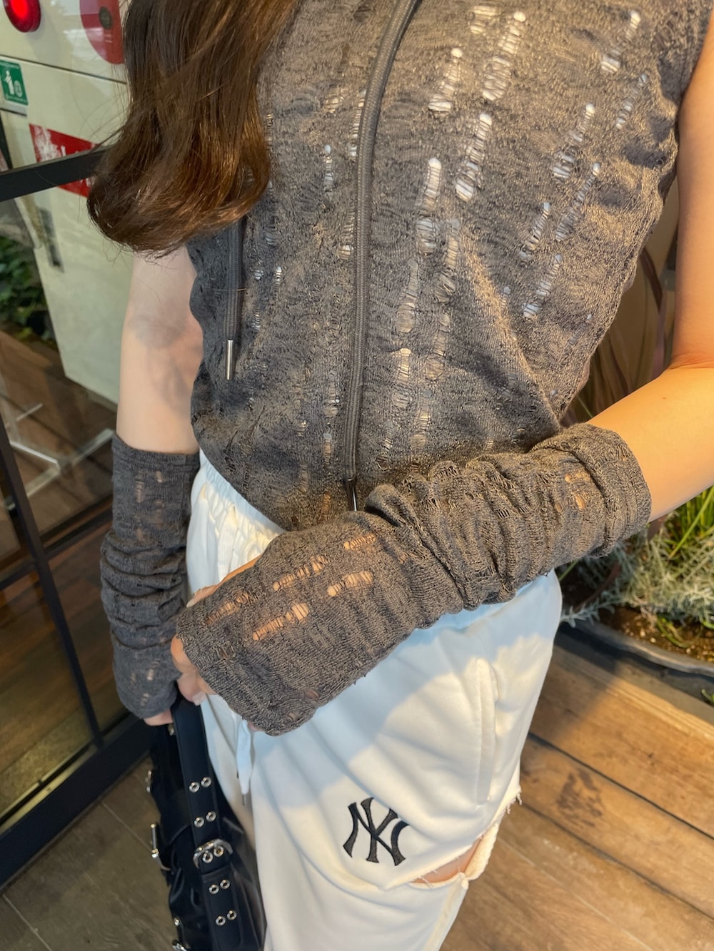 ホワイト系のスウェットパンツ、ブラック系のブーツ、ブラック系のハンドバッグを着用したレディースの春コーディネートの3枚目の写真