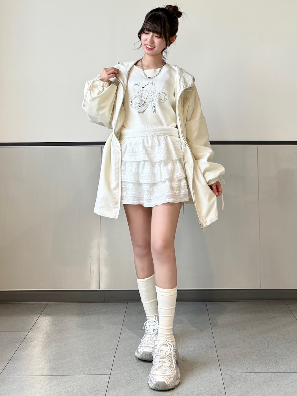 ホワイト系のマウンテンパーカーを着用したレディースの春コーディネートの2枚目の写真