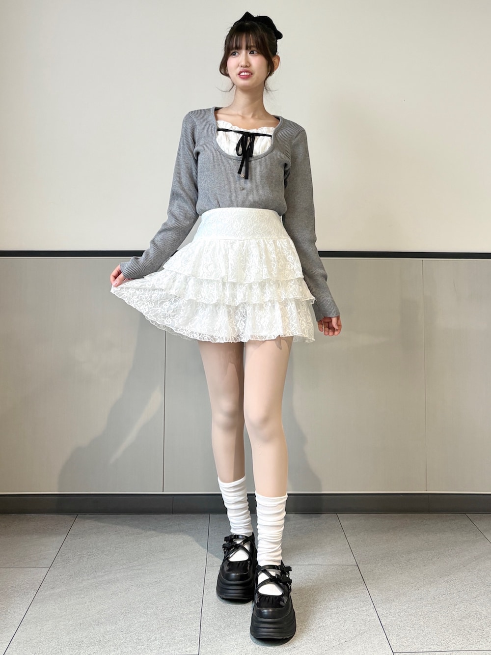 グレー系のニット/セーター、ホワイト系のスカートを着用したレディースの冬コーディネートの3枚目の写真