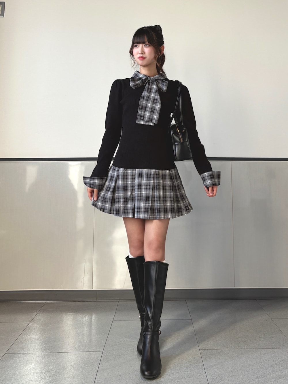 ブラック系のワンピース、ブラック系のハンドバッグ、ブラック系のブーツを着用したレディースの秋コーディネートの3枚目の写真