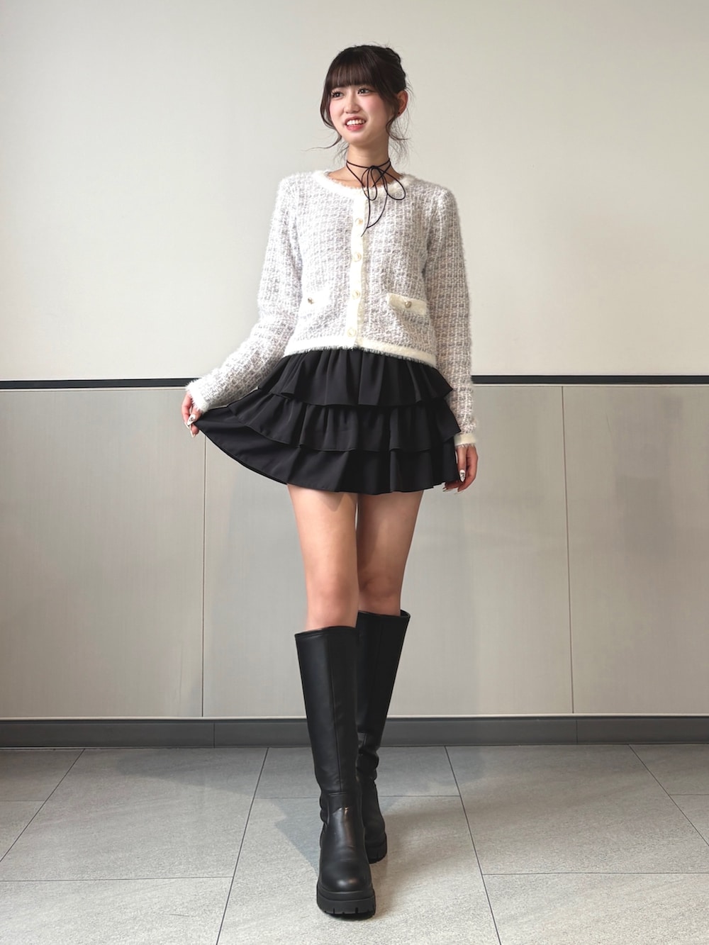 ホワイト系のカーディガン/ボレロ、ブラック系のスカート、ブラック系のブーツを着用したレディースの秋コーディネートの2枚目の写真