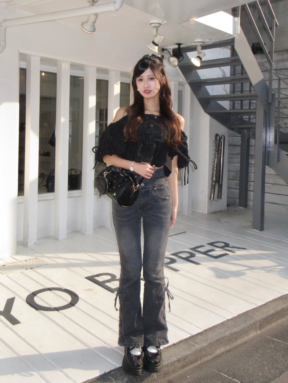 ブラック系のシャツ/ブラウス、ブラック系のボストンバッグを着用したレディースの春コーディネートの2枚目の写真