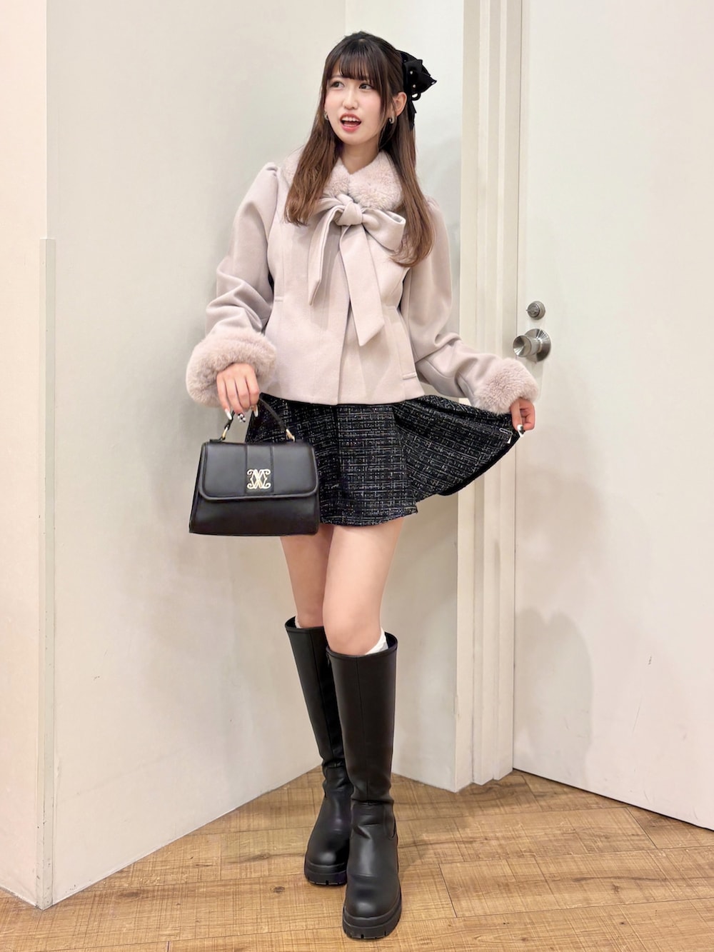 ピンク系のダウンジャケット/コート、ブラック系のスカート、ブラック系のブーツを着用したレディースの冬コーディネートの2枚目の写真