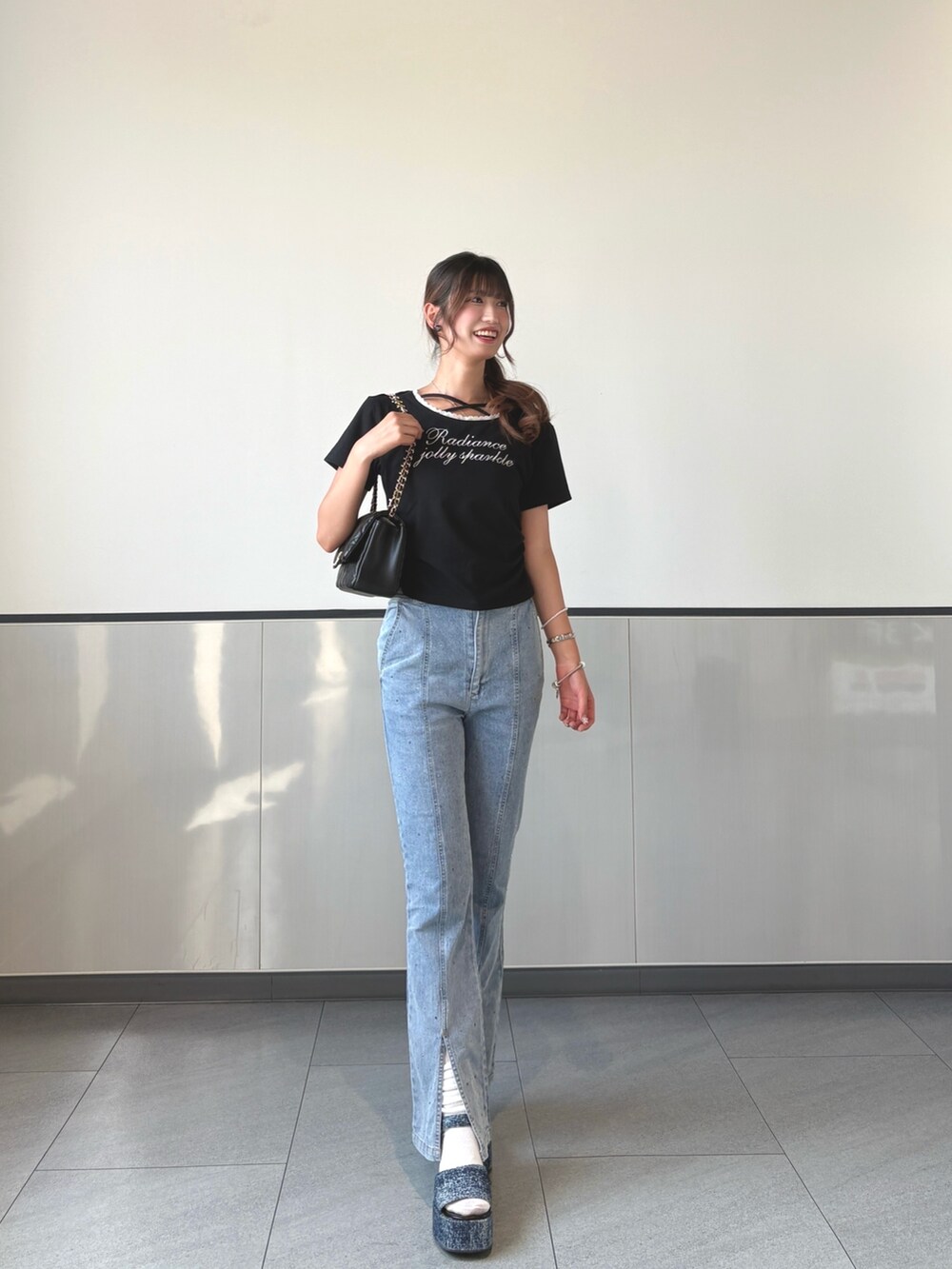 ブラック系のTシャツ/カットソー、ブルー系のデニムパンツ、ブラック系のショルダーバッグを着用したレディースの秋コーディネートの3枚目の写真