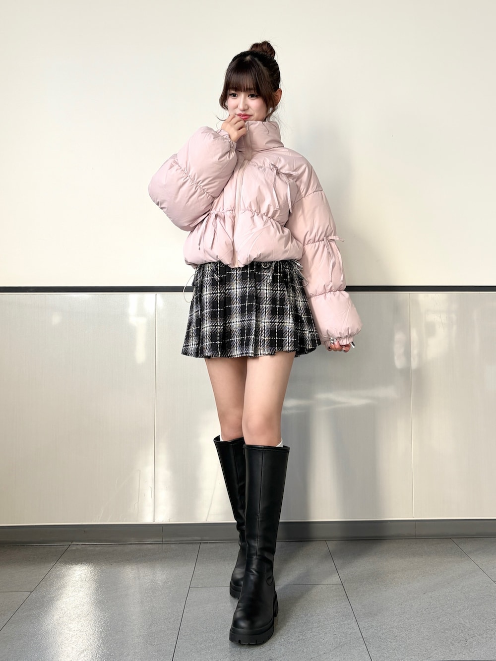 ブラック系のスカート、ブラック系のブーツ、ピンク系のその他アウターを着用したレディースの秋コーディネートの2枚目の写真