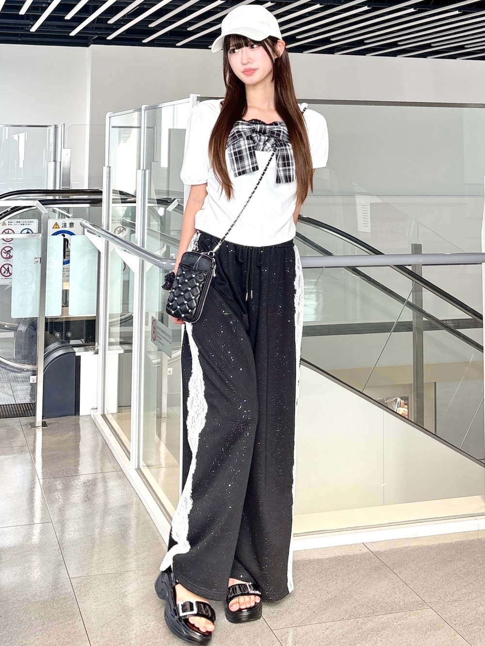 ホワイト系のTシャツ/カットソー、ブラック系のその他パンツ、ブラック系のサンダルを着用したレディースの夏コーディネートの2枚目の写真