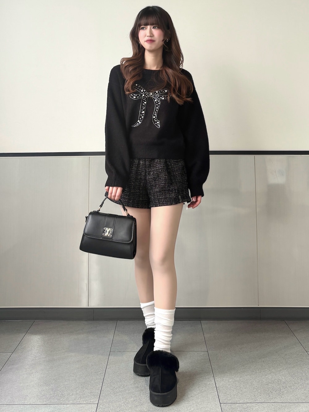 ブラック系のニット/セーター、ブラック系のその他パンツ、ブラック系のブーツを着用したレディースの冬コーディネートの3枚目の写真