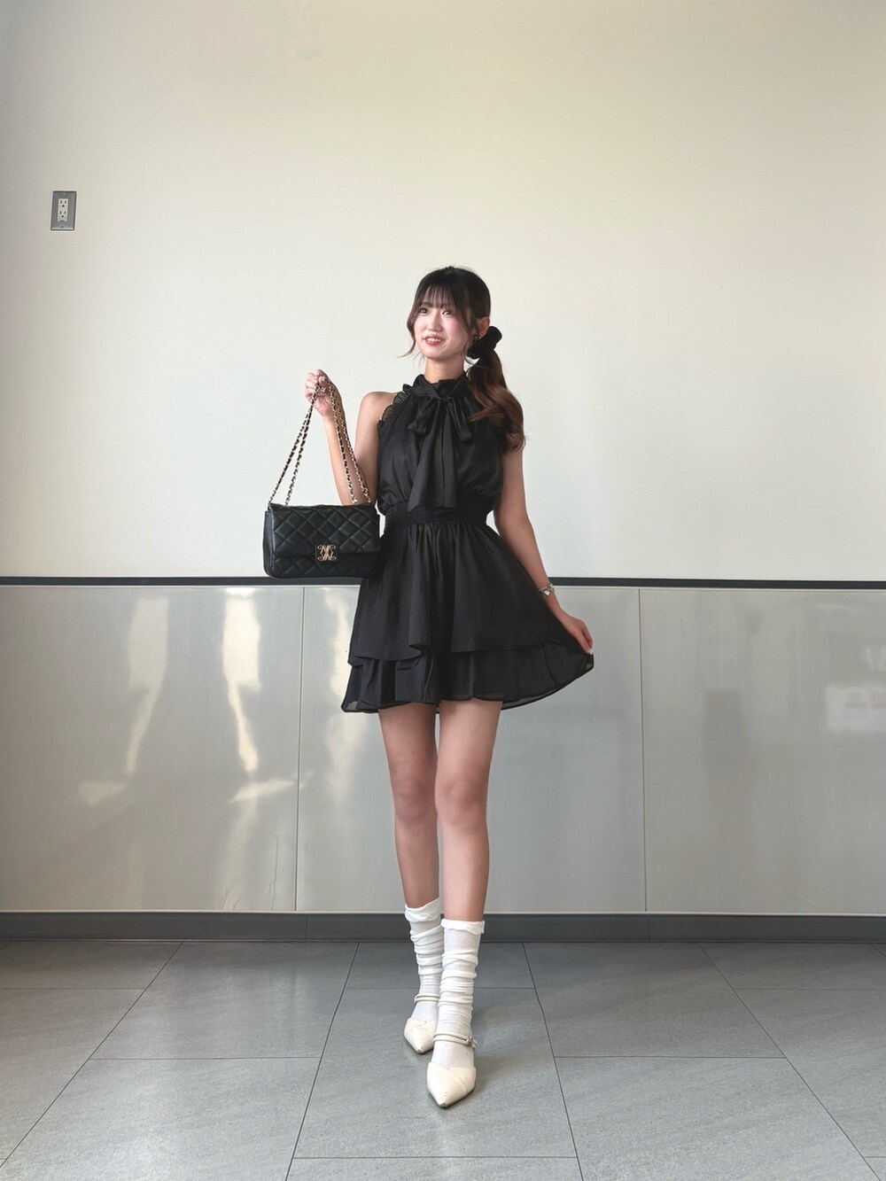 ブラック系のワンピース、ブラック系のショルダーバッグを着用したレディースの秋コーディネートの2枚目の写真