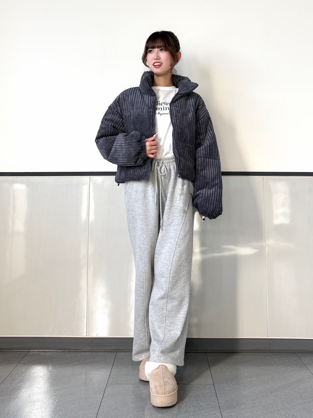 グレー系のダウンジャケット/コート、グレー系のスウェットパンツ、ベージュ系のブーツを着用したレディースの秋コーディネートの2枚目の写真