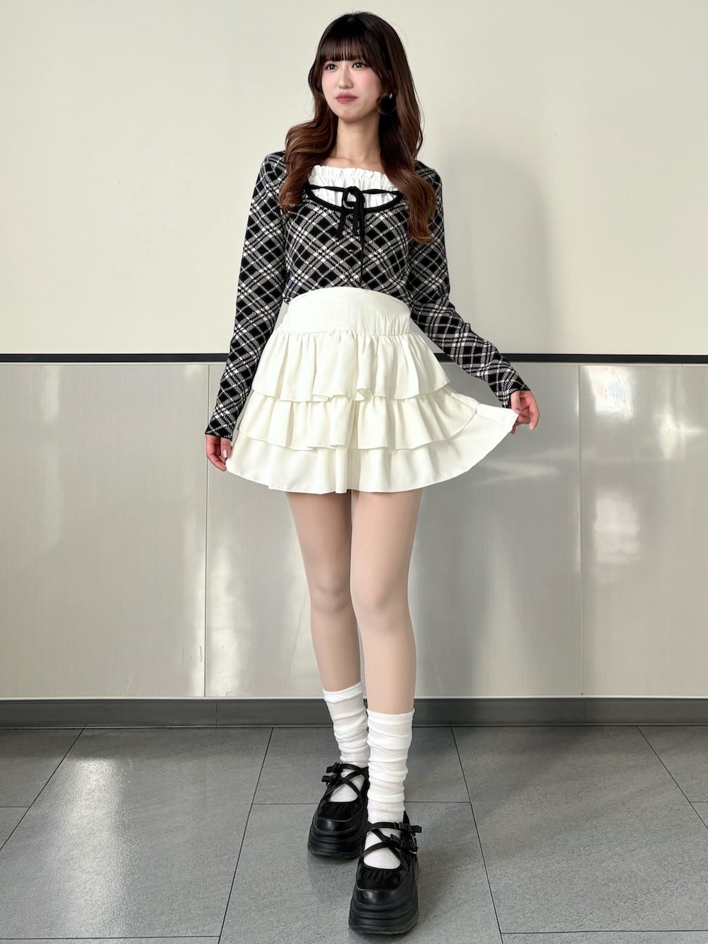 ブラック系のニット/セーター、ホワイト系のスカート、ブラック系のハンドバッグを着用したレディースの冬コーディネートの3枚目の写真