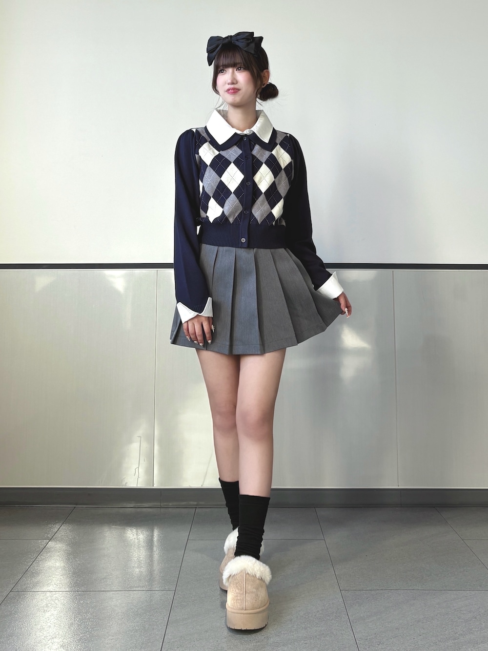 ブルー系のニット/セーター、グレー系のスカート、ベージュ系のブーツを着用したレディースの秋コーディネートの3枚目の写真