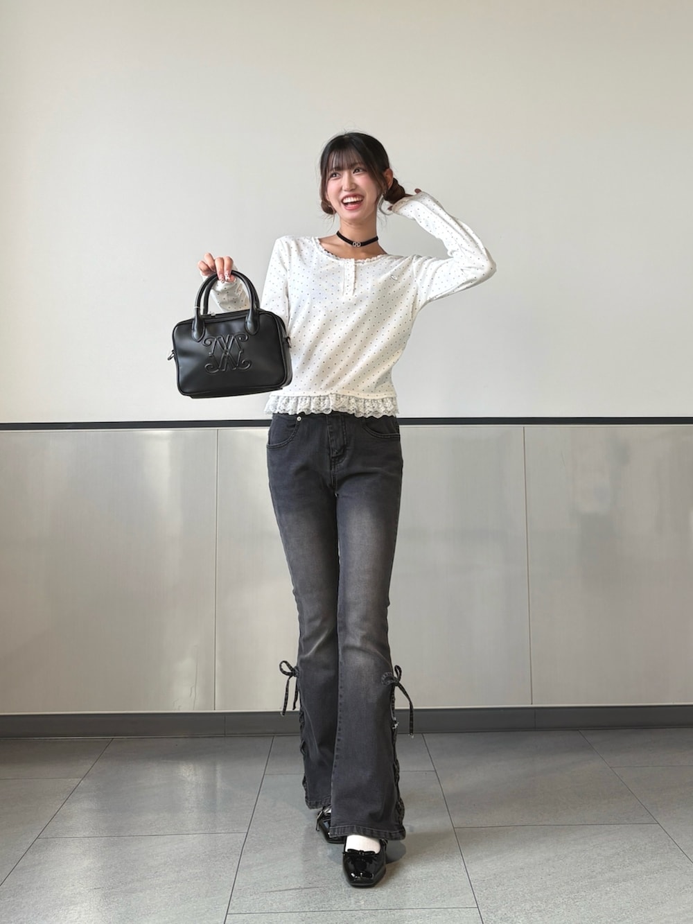 ブラック系のハンドバッグ、ホワイト系のTシャツ/カットソー、ブラック系のパンプスを着用したレディースの秋コーディネートの3枚目の写真