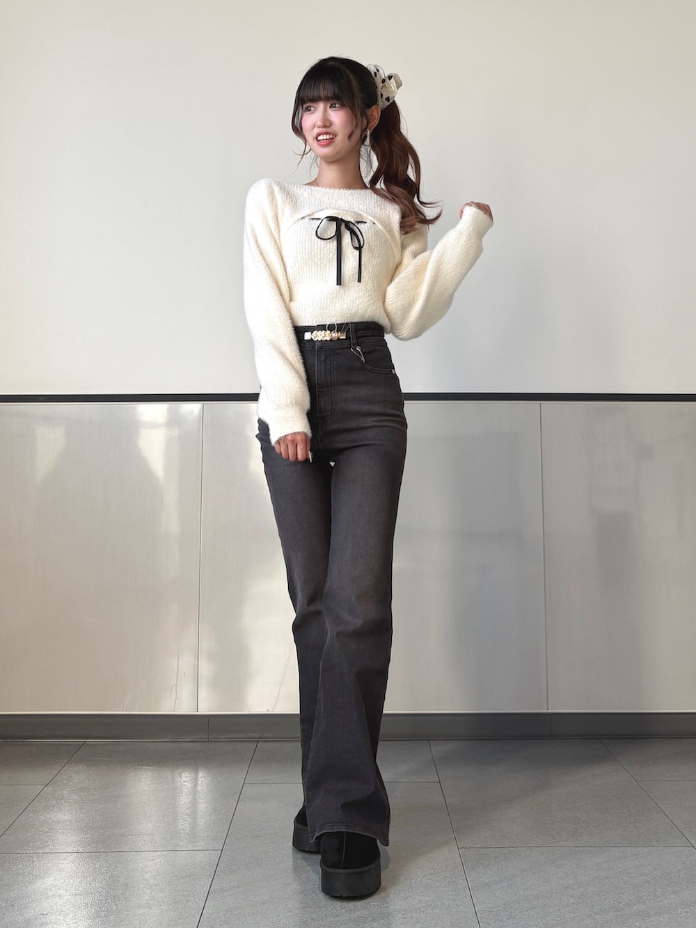 ホワイト系のニット/セーター、グレー系のデニムパンツ、ブラック系のハンドバッグを着用したレディースの秋コーディネートの3枚目の写真