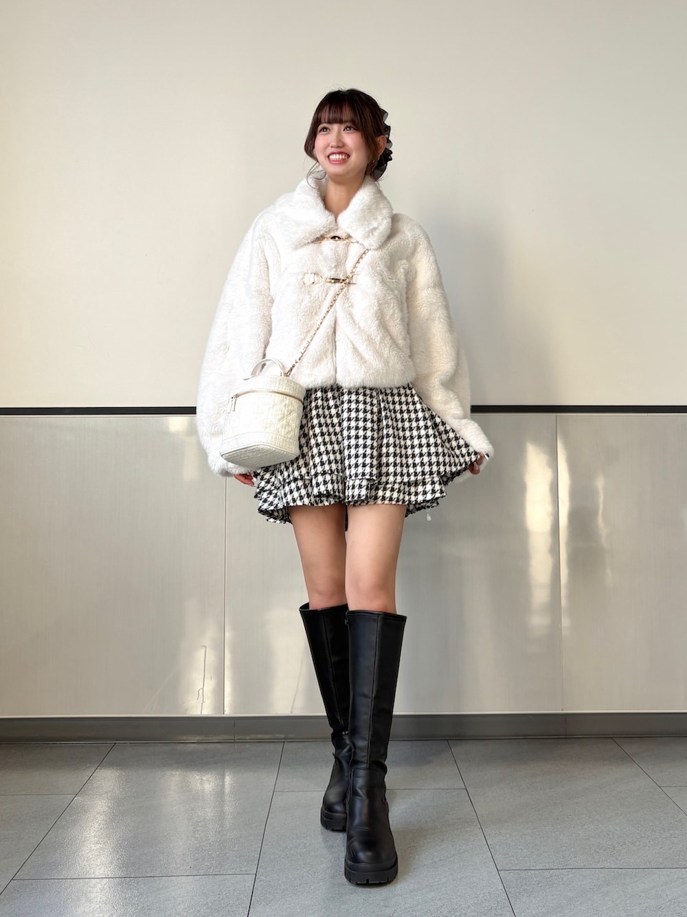 ホワイト系のブルゾン、その他のスカート、ブラック系のブーツを着用したレディースの秋コーディネートの2枚目の写真
