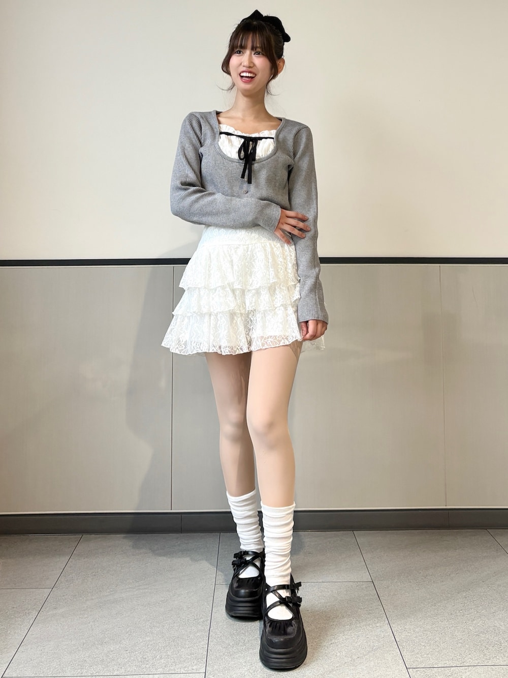 グレー系のニット/セーター、ホワイト系のスカートを着用したレディースの冬コーディネートの2枚目の写真